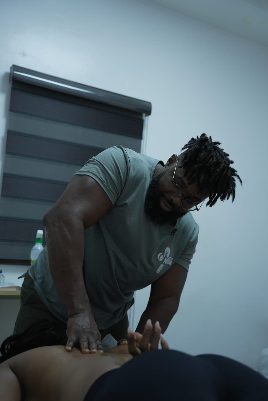 A MYO therapist smiling as he works both palms into a client's lower back